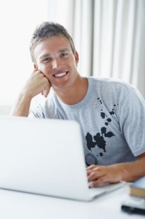 Young man working on laptop. Photographe : momentimages