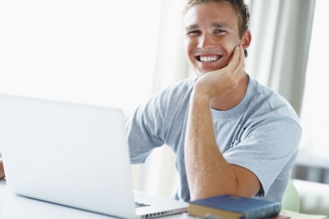 Young man working on laptop. Photographe : momentimages