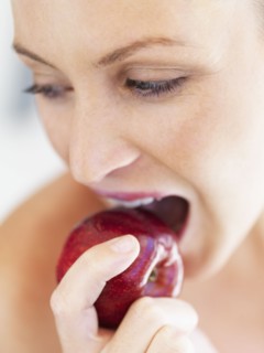 Woman eating an apple. Photographe : momentimages