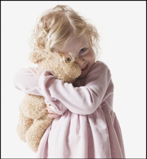 Young girl hugging teddy bear. Photographe : Mike Kemp