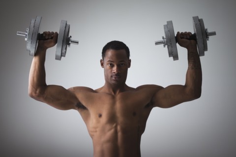 Muscular man lifting dumbbells. Photographe : Mike Kemp
