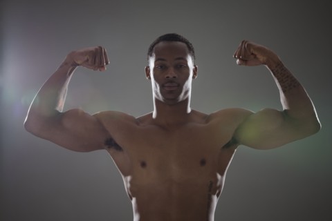 Physically fit man flexing his triceps. Photographe : Mike Kemp