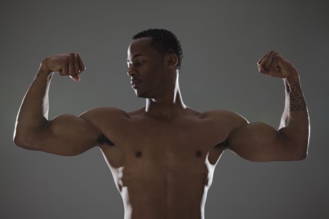 Physically fit man flexing his triceps. Photographe : Mike Kemp