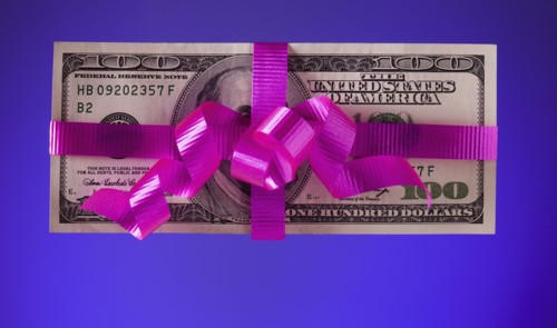 American currency tied with a pink bow. Photographe : Mike Kemp