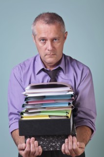 Man holding a stack of paper work. Photographe : RTimages