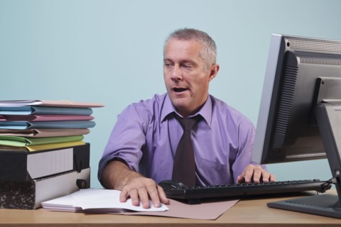 Overworked man sitting at his desk. Photographe : RTimages