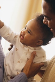 Close-up of mother and father holding their baby. Photographe : Rob Lewine
