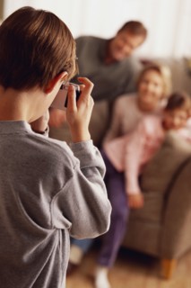 Young boy taking a family picture. Photographe : Rob Lewine