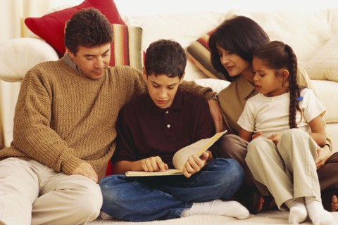 Young boy reading to his family. Photographe : Rob Lewine