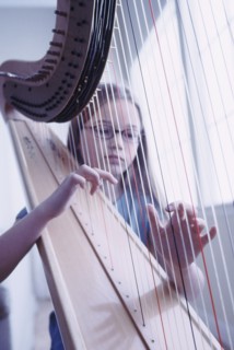 Young girl playing the harp. Photographe : Rob Lewine