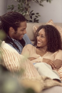 Couple relaxing together on the couch. Photographe : Rob Lewine
