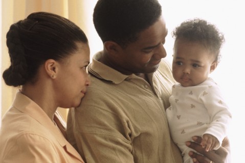 Portrait of parents with their baby. Photographe : Rob Lewine