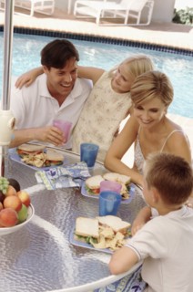 Family eating lunch by the pool. Photographe : Rob Lewine