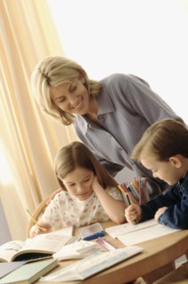 Mother watching her children coloring at the kitchen table. Photographe : Rob Lewine