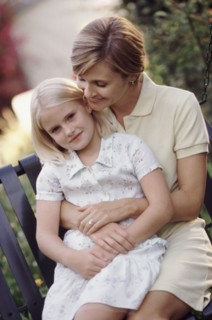 Mother and daughter embracing in the garden. Photographe : Rob Lewine
