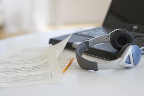 Sheet music headphones and laptop.