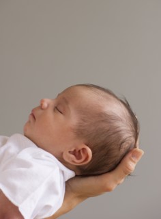 Baby sleeping in mother's hands.