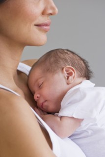 Mother holding sleeping baby.