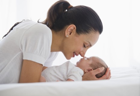 Mother gazing at her sleeping baby.