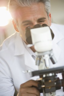 Researcher looking through microscope.