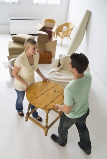 Couple moving furniture in their new home.