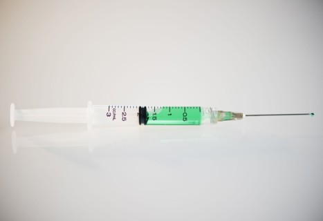 Syringe filled with green liquid. Photo : Jamie Grill