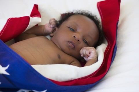 Baby wrapped in American flag. Photo : Daniel Grill