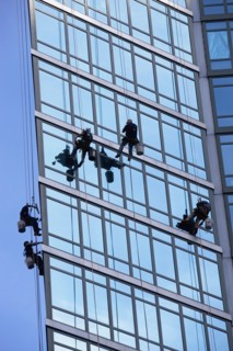 Window washers cleaning windows on skyscraper. Photo : fotog