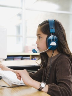 Elementary student wearing headphones in classroom.