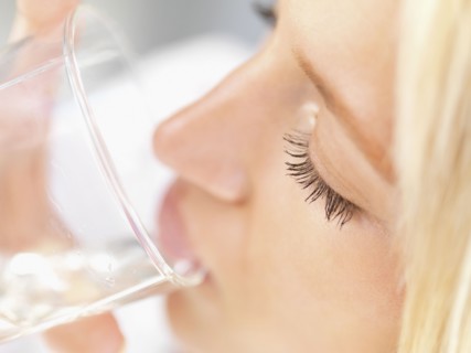 Woman drinking a glass of water. Photo : momentimages