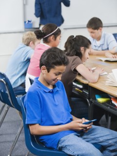 Student texting in classroom.