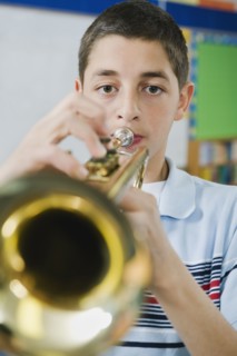 Elementary school student playing trumpet.