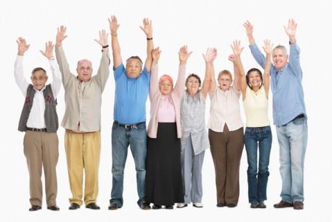 A group of people standing in a row raising their arms. Photo : momentimages