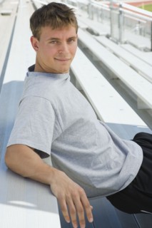 Confident athlete sitting on bleachers. Photo : Stewart Cohen