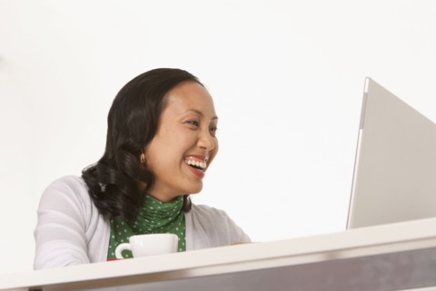 Happy woman looking at laptop. Photo : K.Hatt