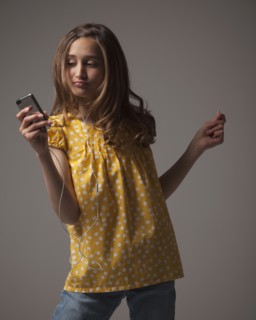 Teenage girl listening to music on I pod. Photo : Mike Kemp