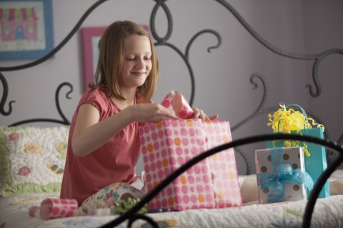 Young girl wrapping presents. Photo : Mike Kemp
