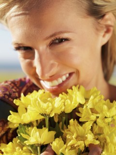 Woman holding yellow flowers. Photo : momentimages
