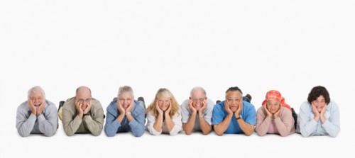 A group of people lying on the floor in a row. Photo : momentimages