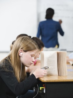 Student texting in classroom.