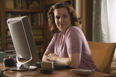 Woman sitting at desk in home office. Photo : Stewart Cohen