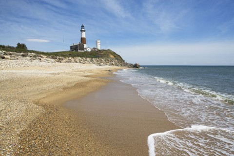Beach with lighthouse in background. Photo : fotog