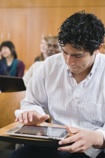 College students taking notes in lecture hall.