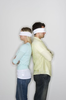 Blindfolded couple standing back to back.