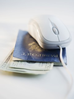 Computer mouse on top of passport and money. Photo : Jamie Grill