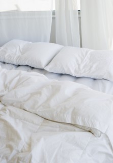 Bed with white linens.