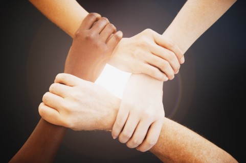 Four hands holding wrists of other people.