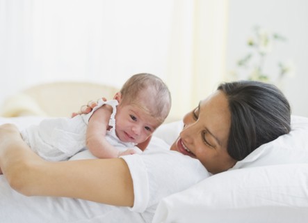 Mother lying down with her baby.