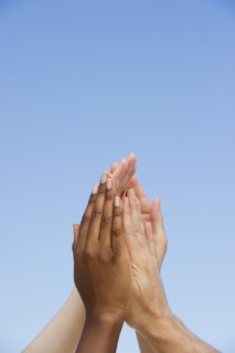 Four hands reaching up.
