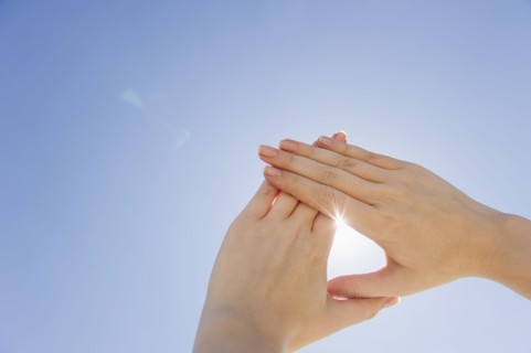 Hands framing sunshine.